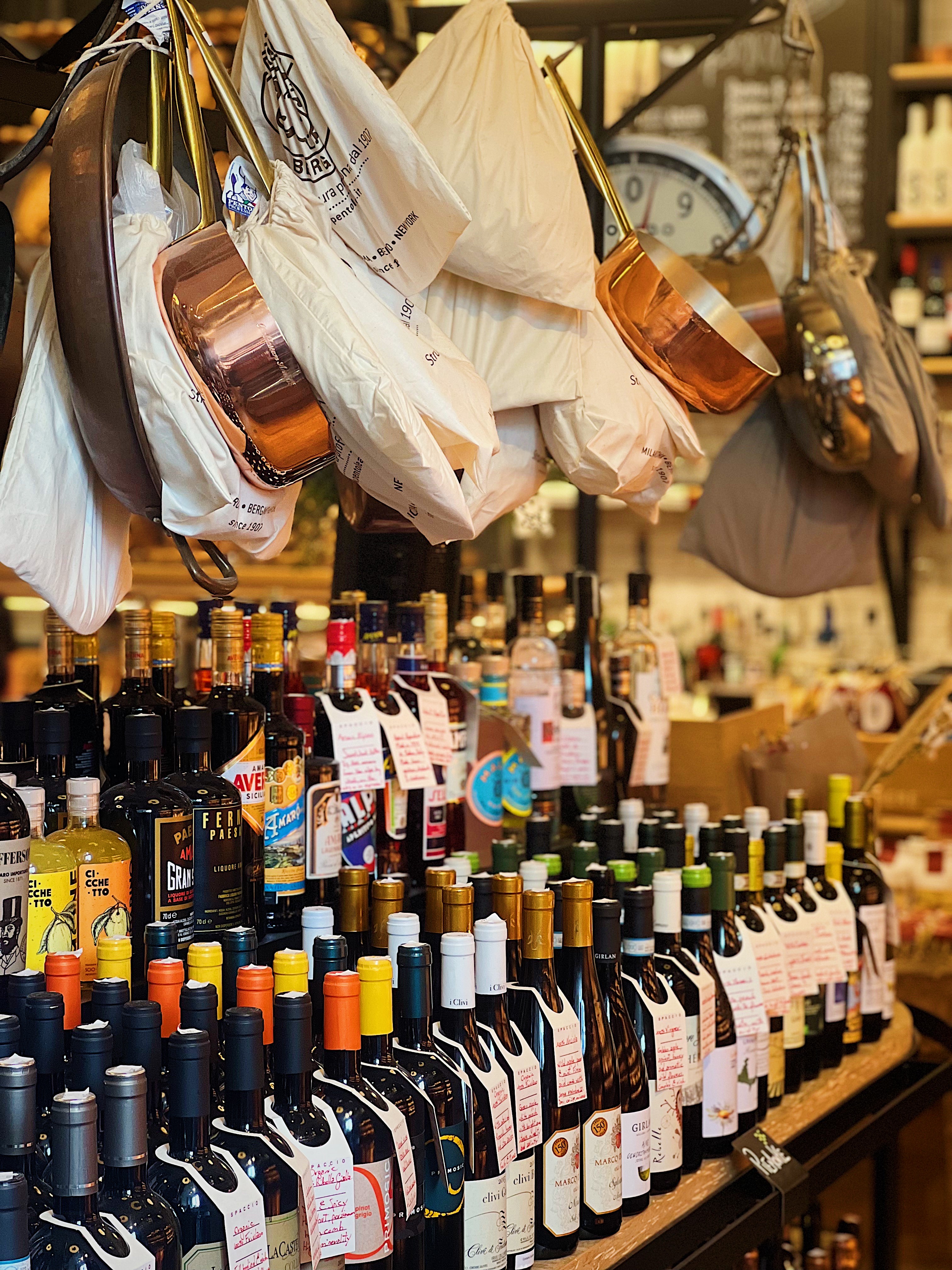 picture of mulitple rows of wine bottles and hanging pots and pans at a bakery