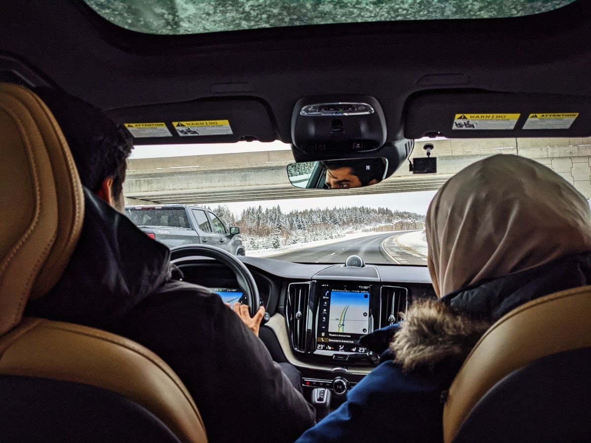 picture of a couple (male & female) taking a drive during snowy winter