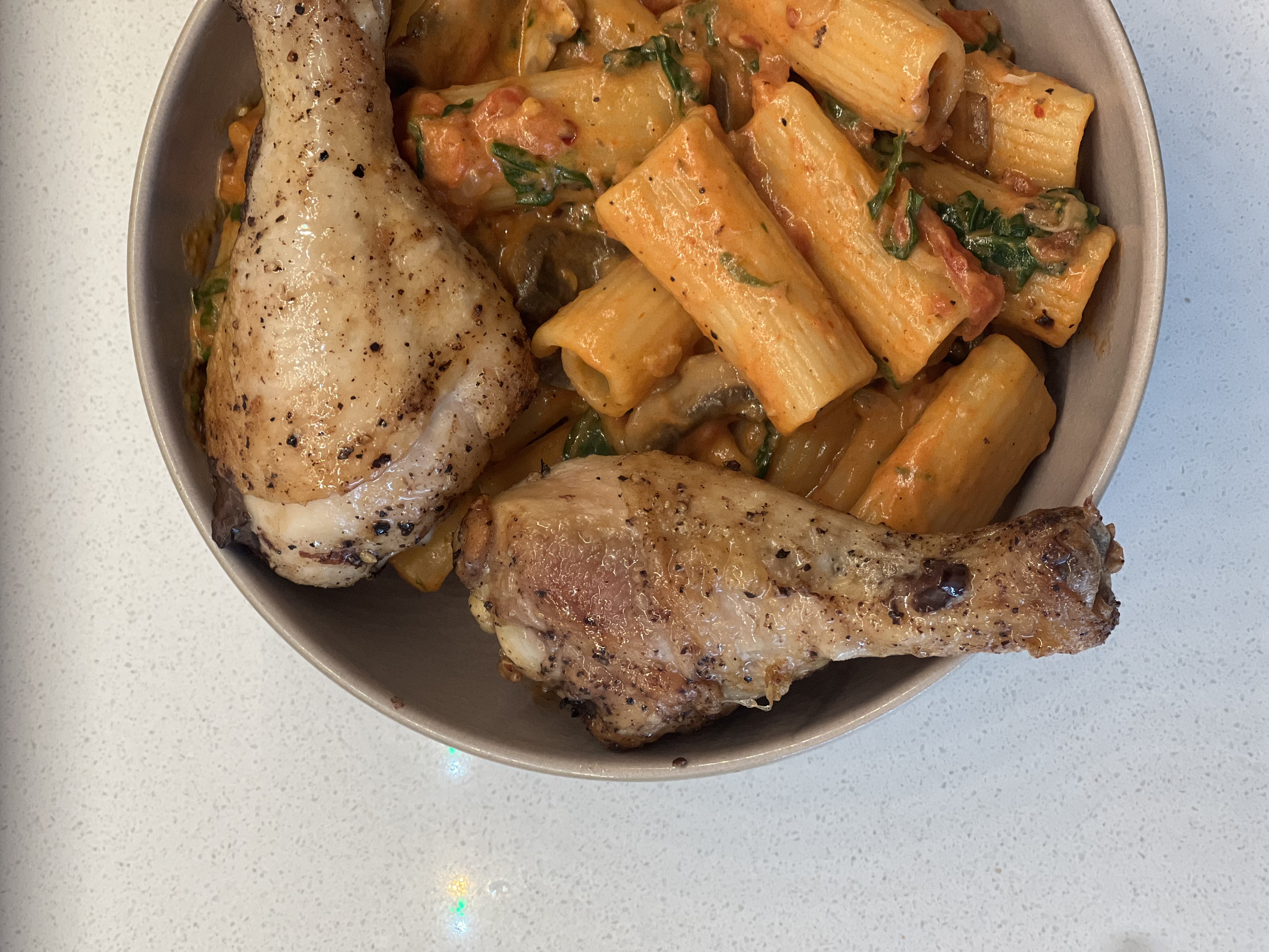 picture of a bowl of pasta and baked chicken legs